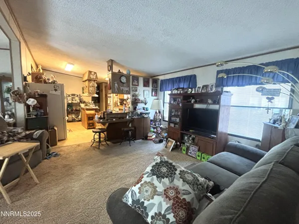 a living room with furniture kitchen view and a large window