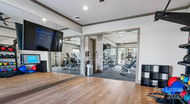 a hallway with wooden floor a fireplace and a baby crib