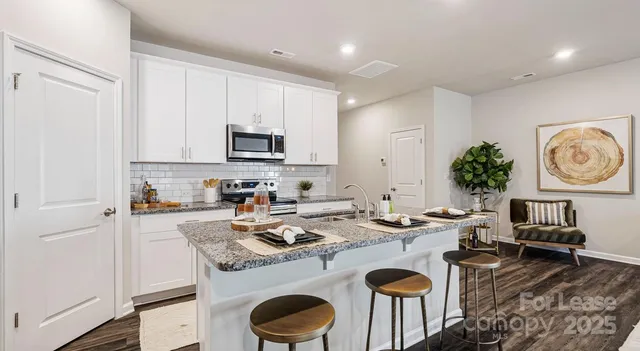 a kitchen with stainless steel appliances granite countertop a stove and a white cabinets