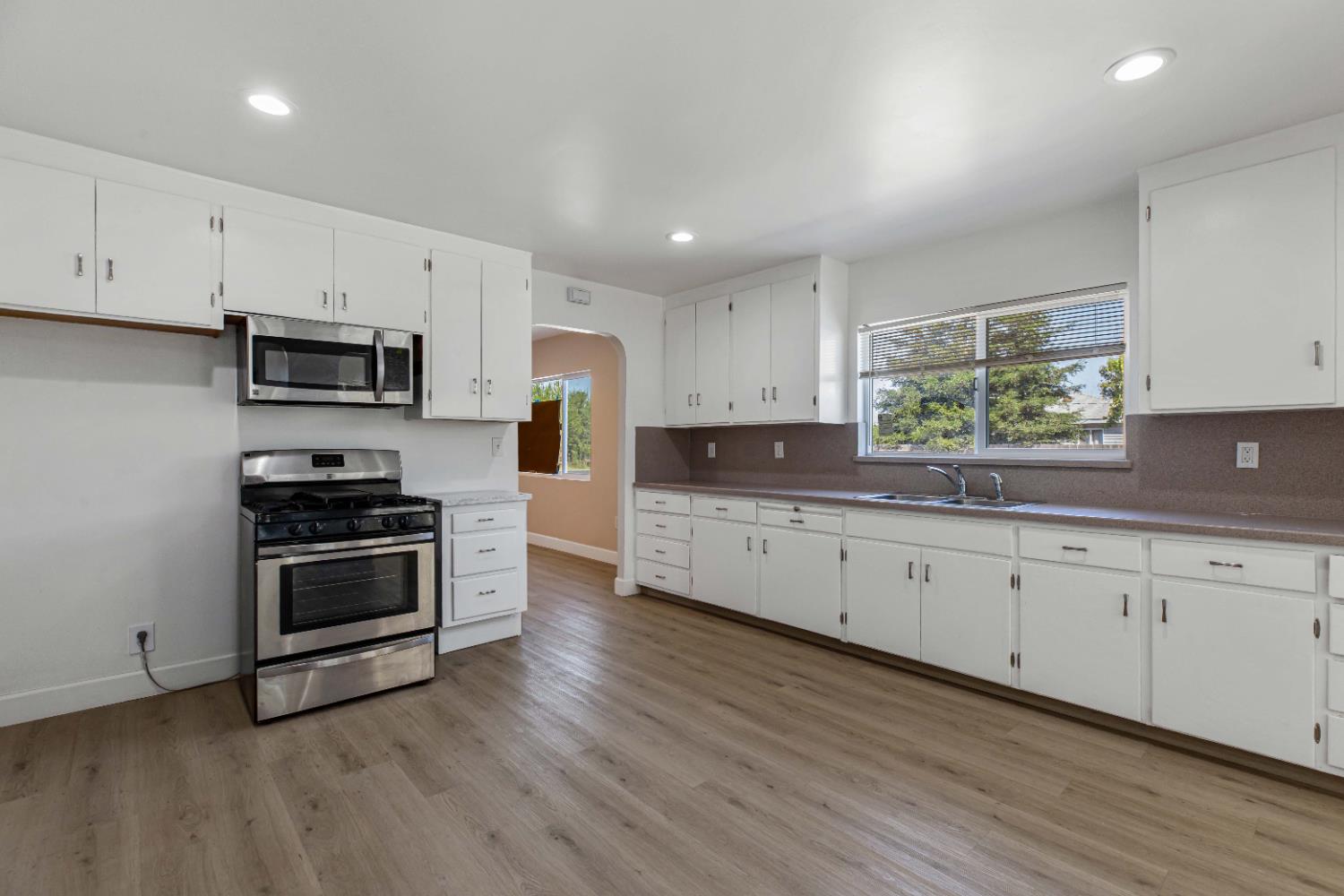 a kitchen with stainless steel appliances granite countertop a stove a sink and a microwave