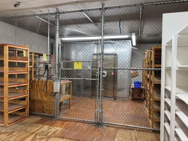 a kitchen with stainless steel appliances kitchen island granite countertop a stove top oven a sink dishwasher and a refrigerator with wooden floor