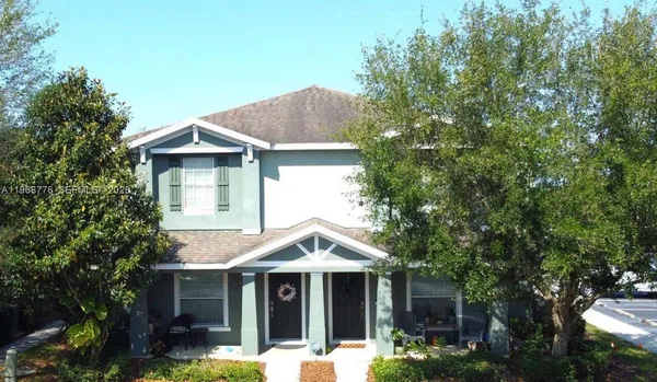 a view of a house with a yard and potted plants