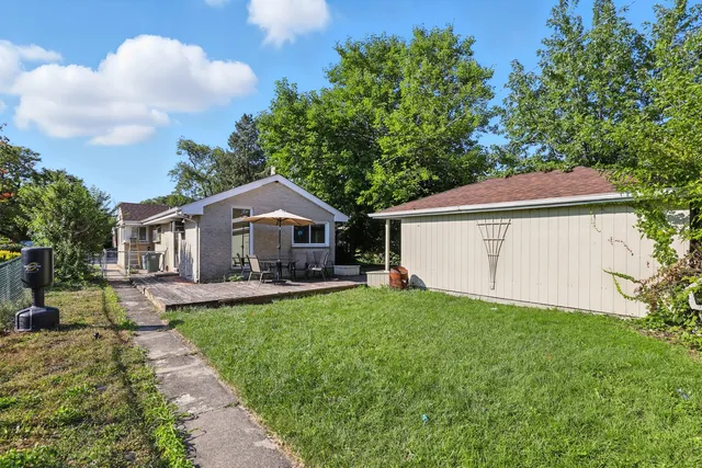 a front view of house with yard and trees in the background
