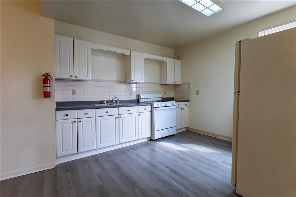 832 Broadway Avenue McKees Rocks, PA 15136 - Photo 3 of 48 a kitchen with granite countertop white cabinets and white appliances
