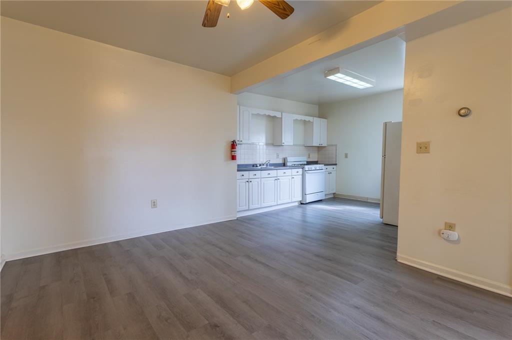 832 Broadway Avenue McKees Rocks, PA 15136 - Photo 9 of 48 wooden floor in an empty room with a kitchen