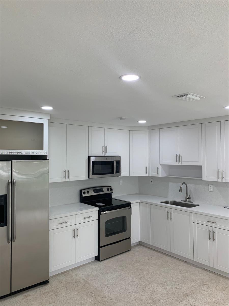 Driftwood Acres Hollywood, FL 33024 - Photo 1 of 21 a kitchen with stainless steel appliances and white cabinets