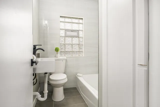 a bathroom with a toilet a sink and a window