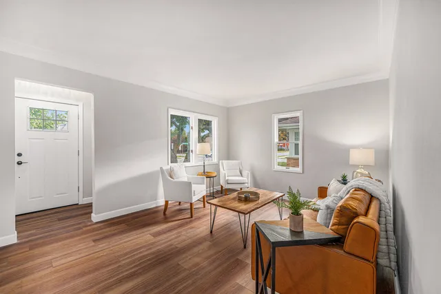 a living room with furniture a wooden floor and a window