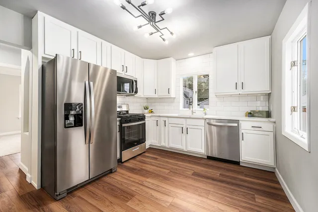 a kitchen with stainless steel appliances a refrigerator sink and microwave