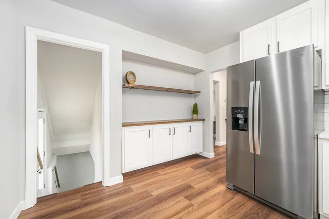 a kitchen with stainless steel appliances a refrigerator and wooden floor