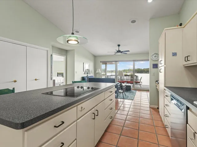 a big room with windows and view of kitchen