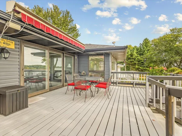 a view of a patio with table and chairs with wooden floor and fence