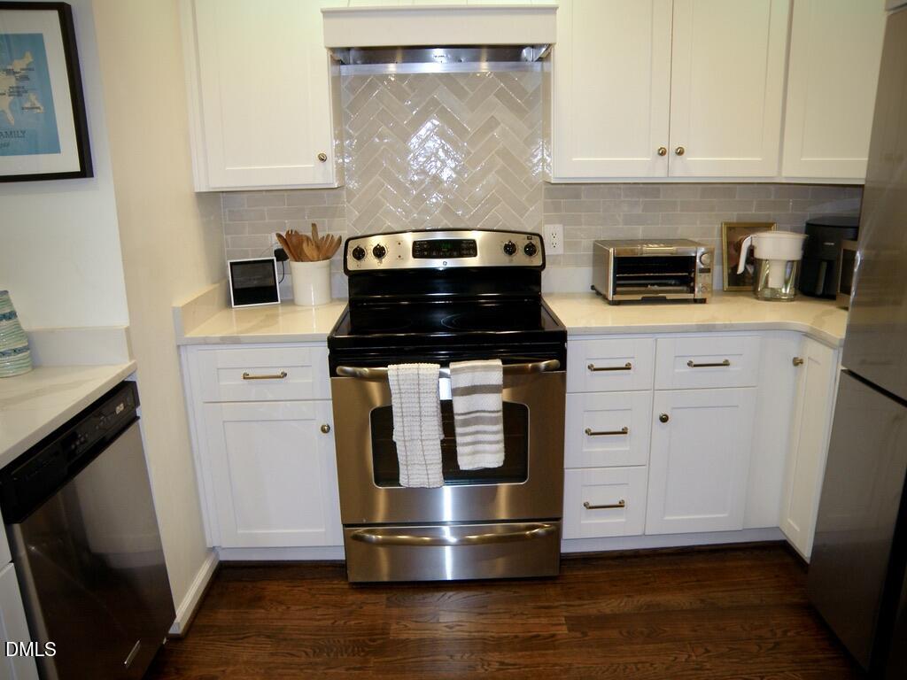 2858 Wycliff Road Raleigh, NC 27607 - Photo 13 of 26 a kitchen with granite countertop white cabinets and a stove with wooden floor