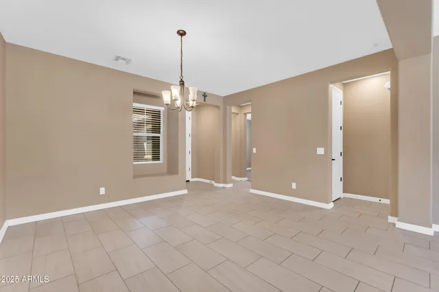 an empty room with windows and ceiling fan