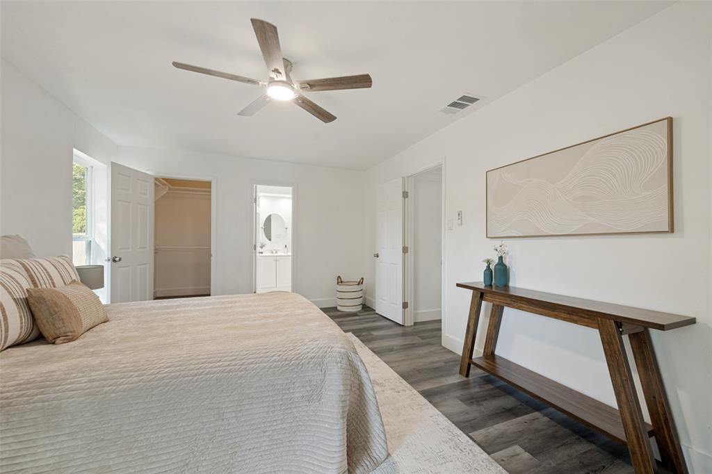 3004 Raintree Court Bedford, TX 76021 - Photo 16 of 25 Wood-finish flooring, ceiling fan with integrated lighting, built-in closet with shelving, and an en-suite bathroom with a circular mirror and vanity