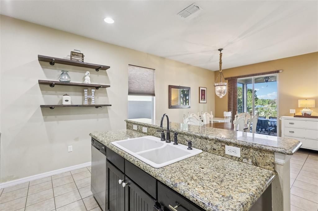 1689 Strathmore Circle Mount Dora, FL 32757 - Photo 11 of 37 a bathroom with a granite countertop sink a mirror and shower