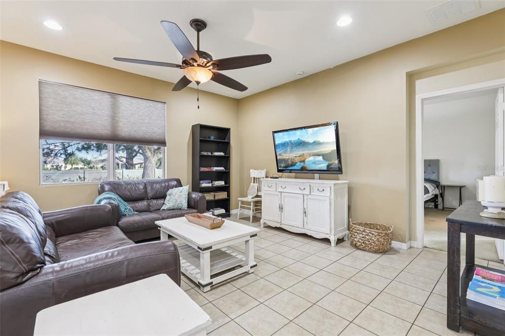 1689 Strathmore Circle Mount Dora, FL 32757 - Photo 13 of 37 a living room with furniture and a flat screen tv