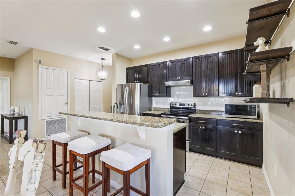 1689 Strathmore Circle Mount Dora, FL 32757 - Photo 9 of 37 a kitchen with stainless steel appliances granite countertop a stove top oven a sink refrigerator and cabinets
