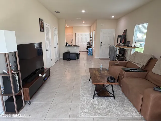 a living room with furniture a flat screen tv and a table