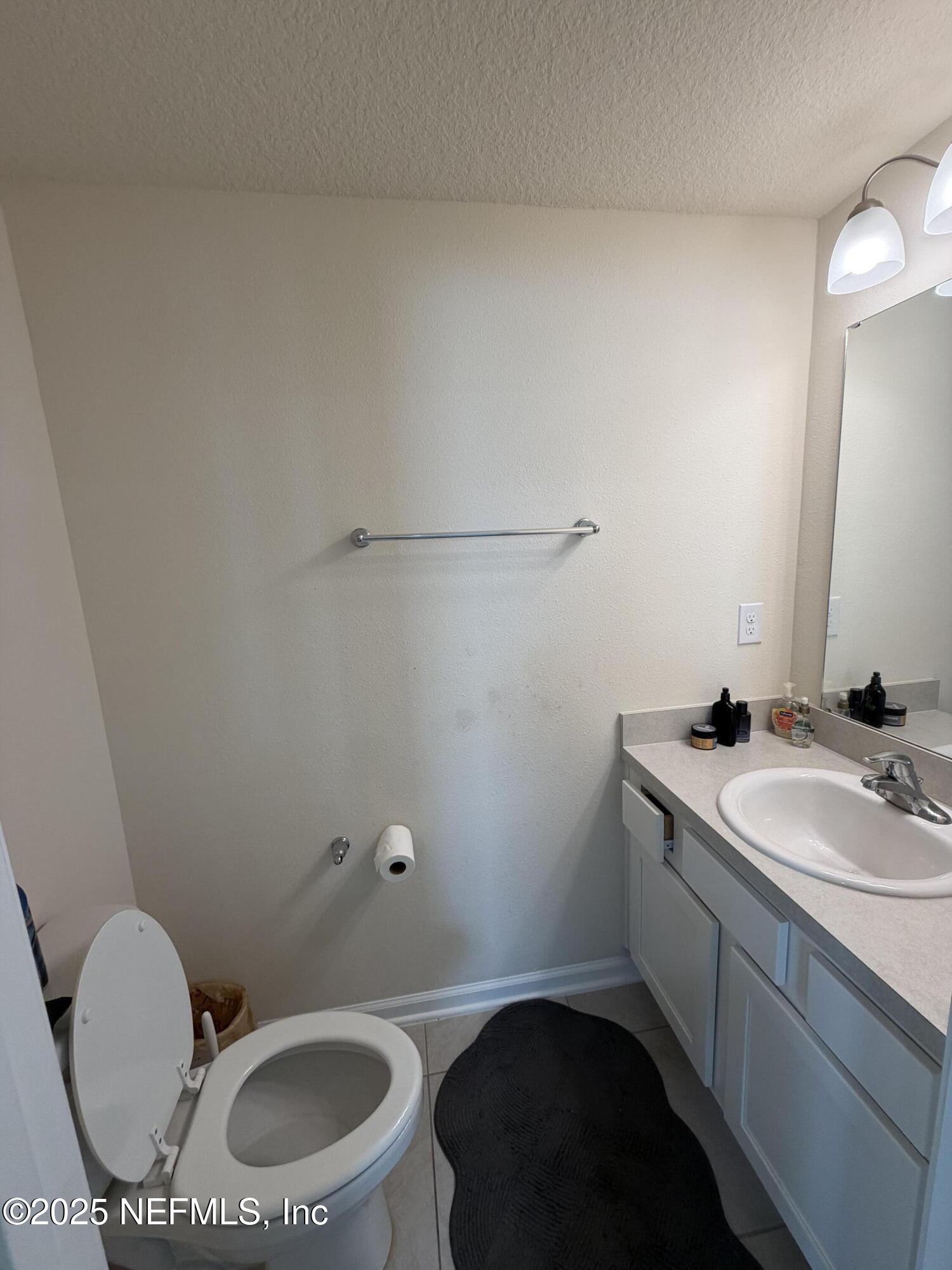64 Java Lane St. Augustine, FL 32092 - Photo 15 of 38 a bathroom with a granite countertop sink mirror vanity and toilet
