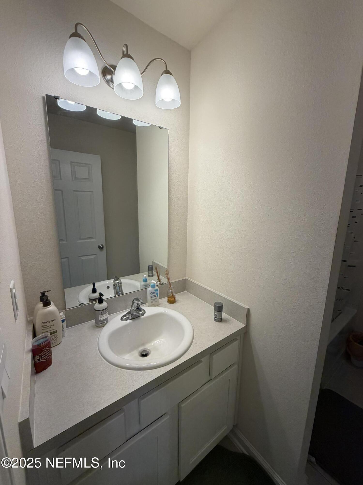 64 Java Lane St. Augustine, FL 32092 - Photo 27 of 38 a bathroom with a sink vanity and a mirror