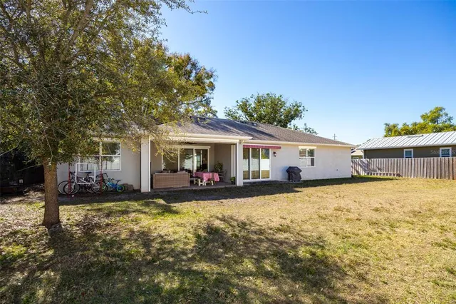 a view of a house with a big yard and large tree
