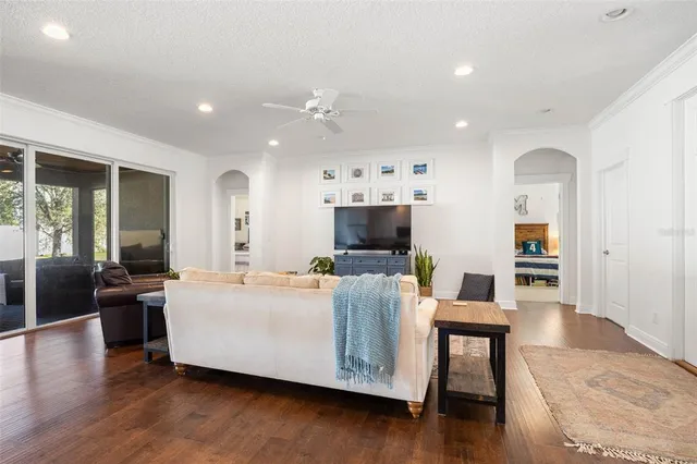 a living room with furniture a flat screen tv and a refrigerator