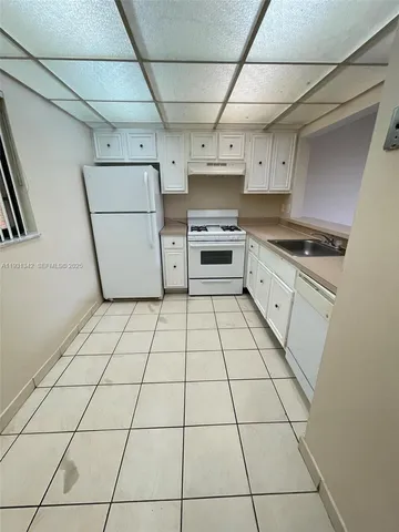 a kitchen with a stove a sink and a refrigerator