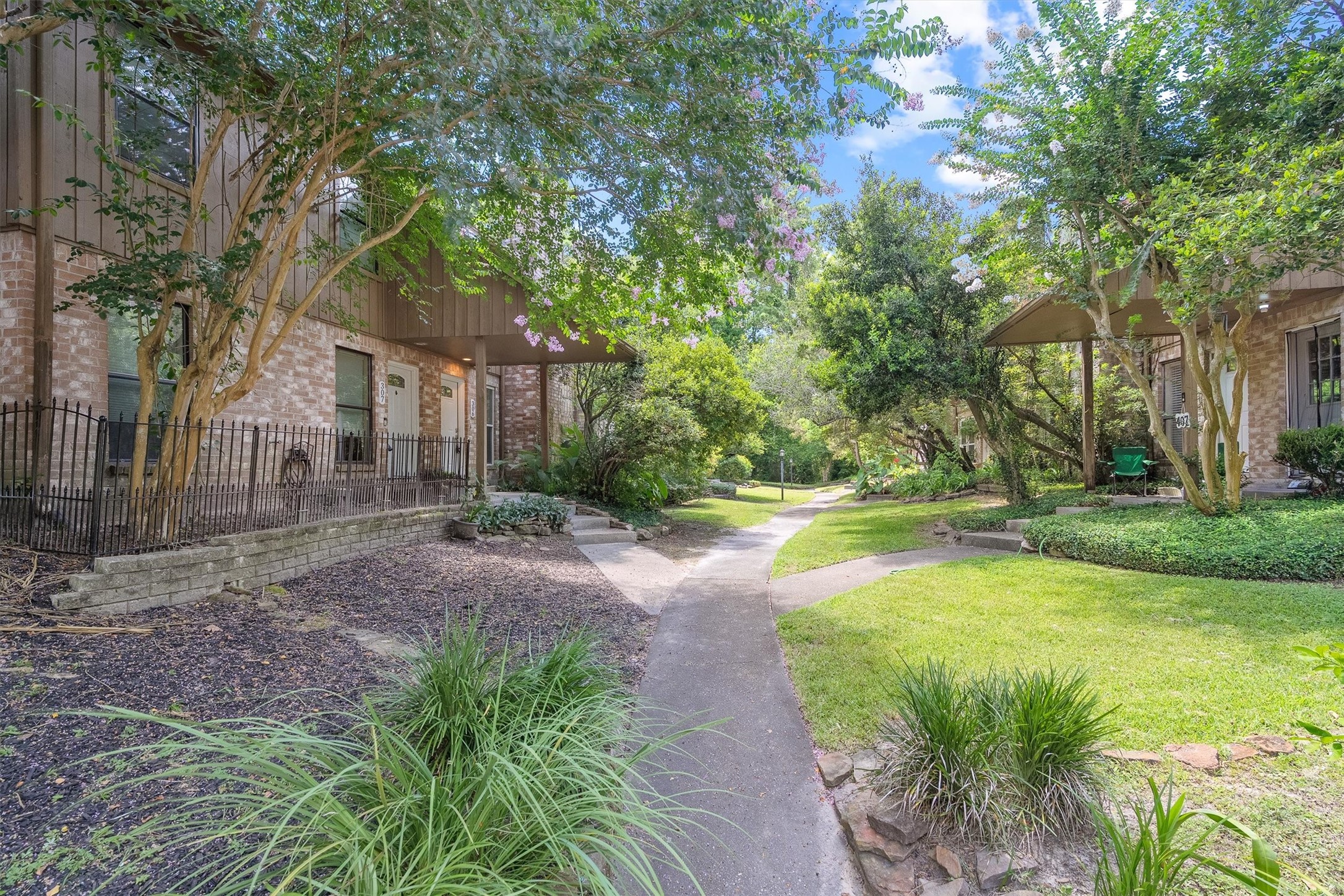 1011 Hamblen Road, Unit 306 Houston, TX 77339 - Photo 2 of 38 A shared courtyard connects neighboring units here, framed by mature landscaping that gives the whole community a lush, established feel.