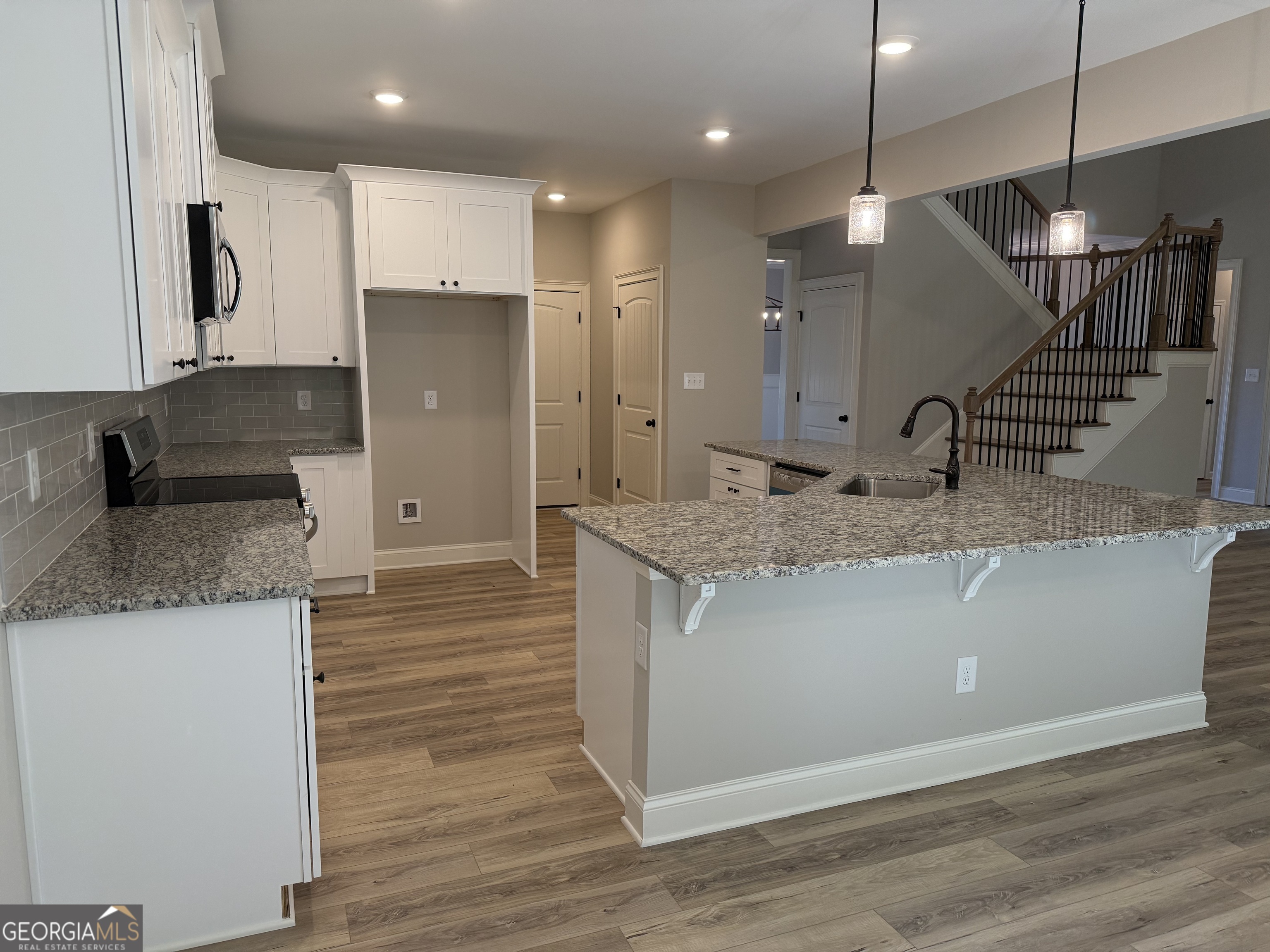 92 Commanche Circle Williamson, GA 30292 - Photo 25 of 53 a kitchen with kitchen island granite countertop wooden cabinets and a granite counter tops