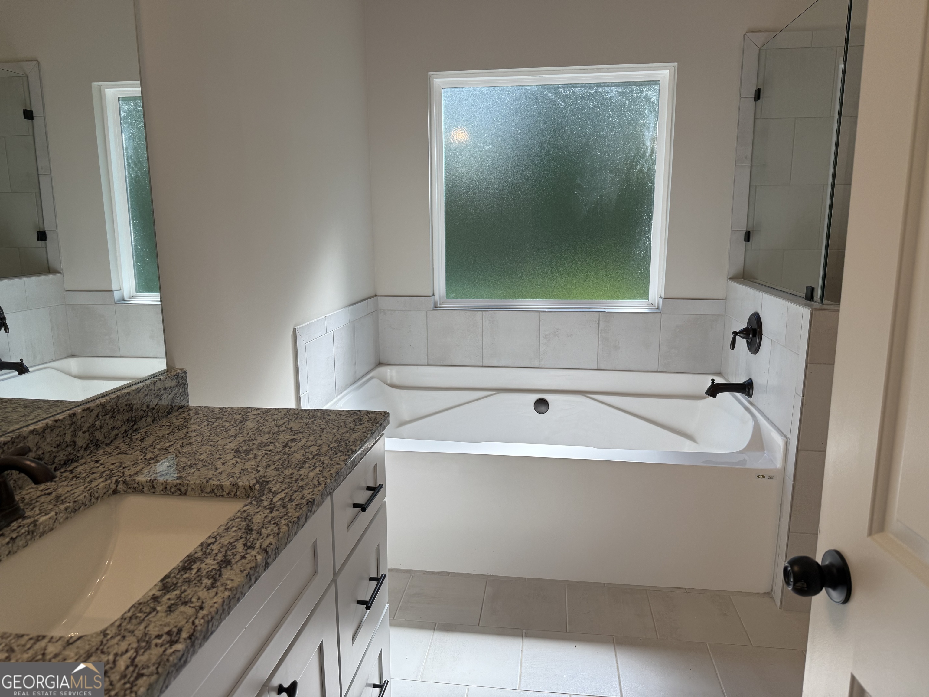 92 Commanche Circle Williamson, GA 30292 - Photo 40 of 53 a bathroom with a granite countertop sink and mirror with bathtub
