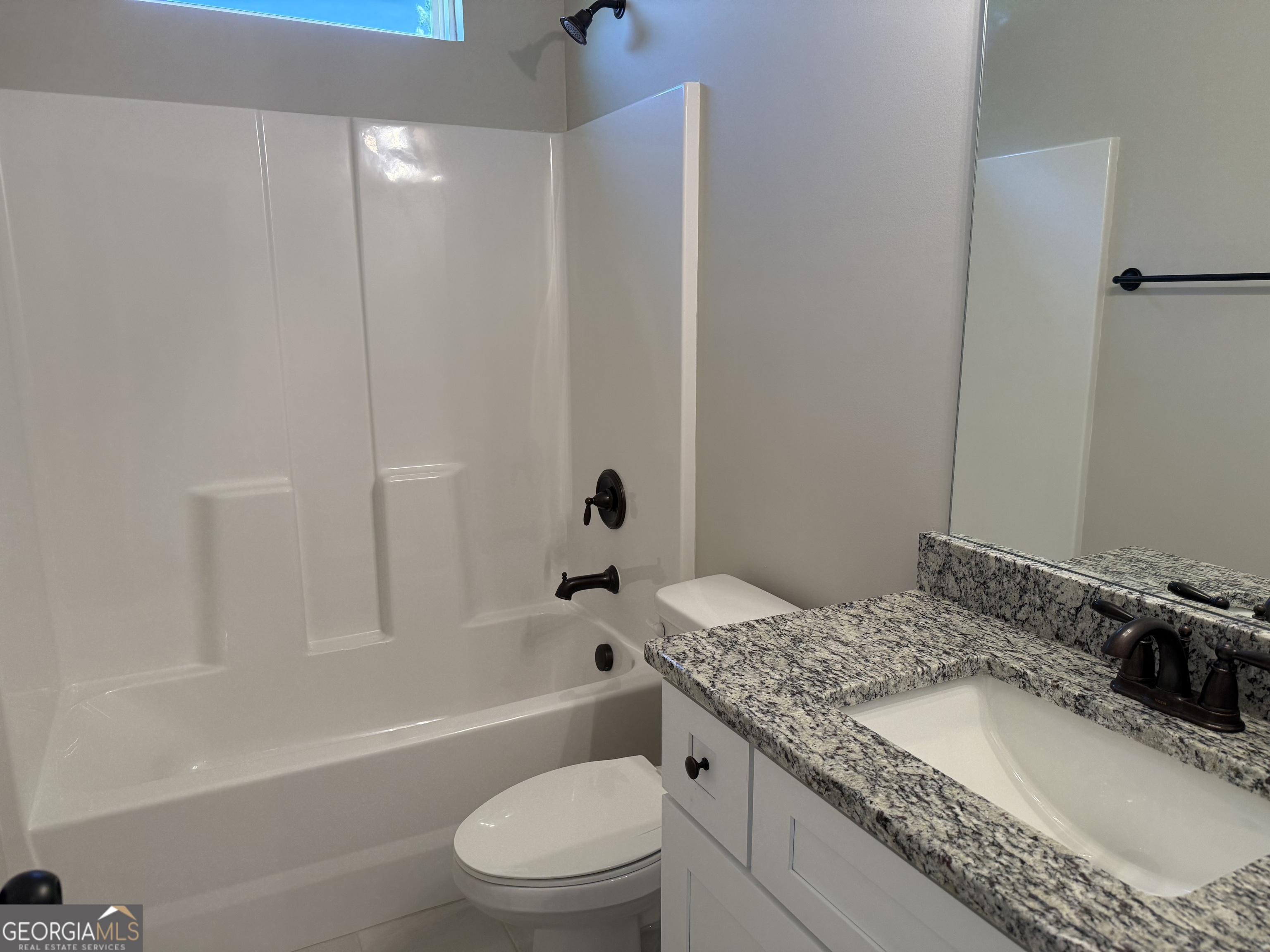 92 Commanche Circle Williamson, GA 30292 - Photo 48 of 53 a bathroom with a granite countertop bathtub shower sink vanity mirror and toilet