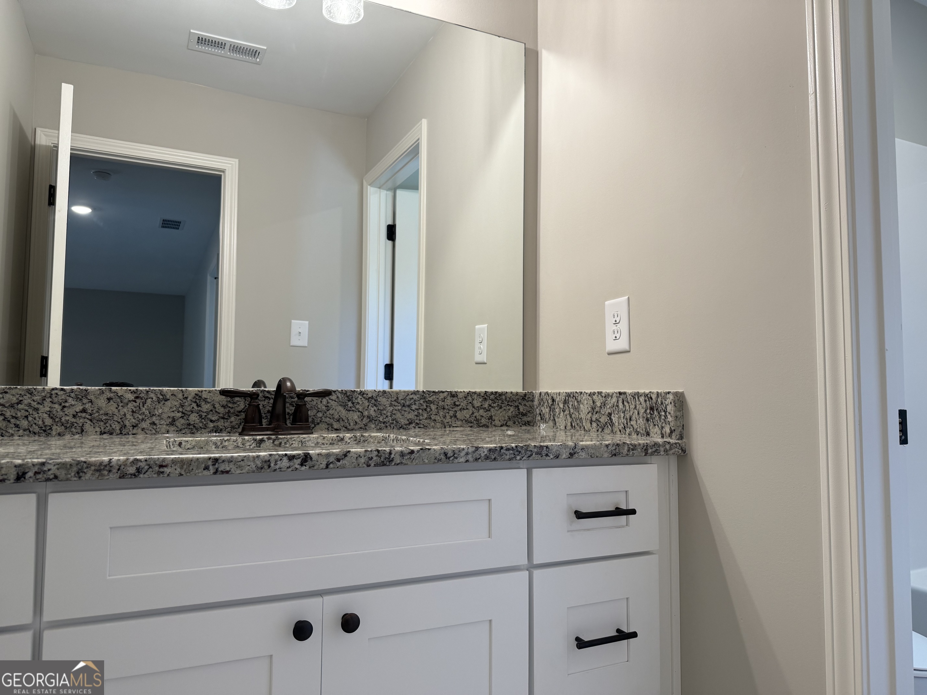92 Commanche Circle Williamson, GA 30292 - Photo 51 of 53 a bathroom with a granite countertop sink and vanity