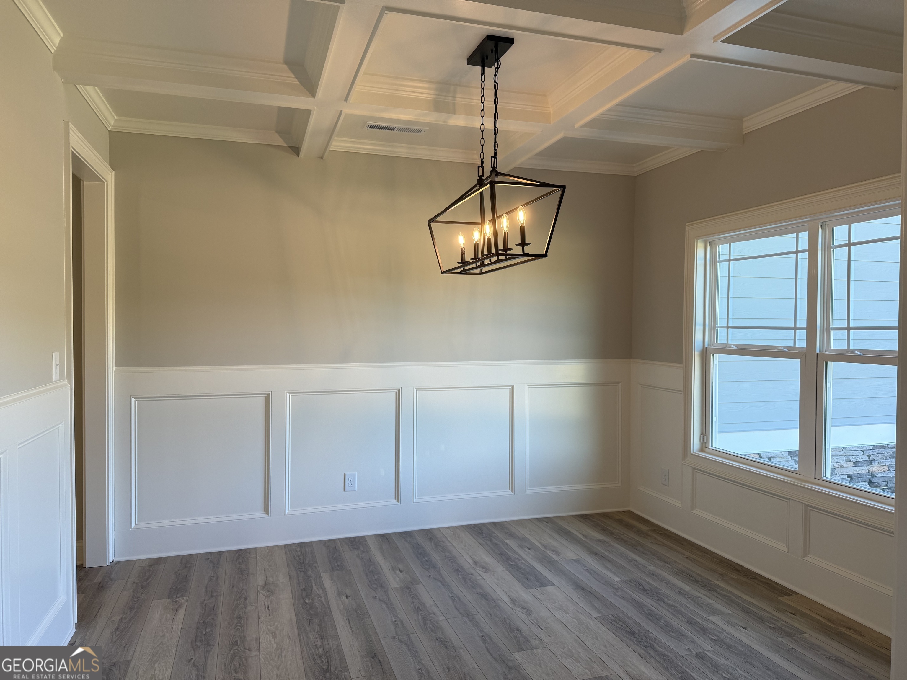 92 Commanche Circle Williamson, GA 30292 - Photo 7 of 53 an empty room with wooden floor chandelier and windows