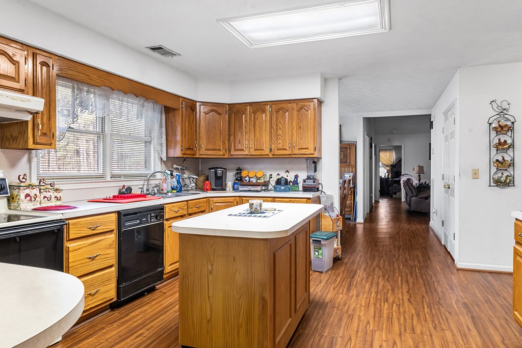 1085 Terry Lane Fortson, GA 31808 - Photo 10 of 21 a kitchen with wooden cabinets a sink dishwasher and a stove with wooden floor