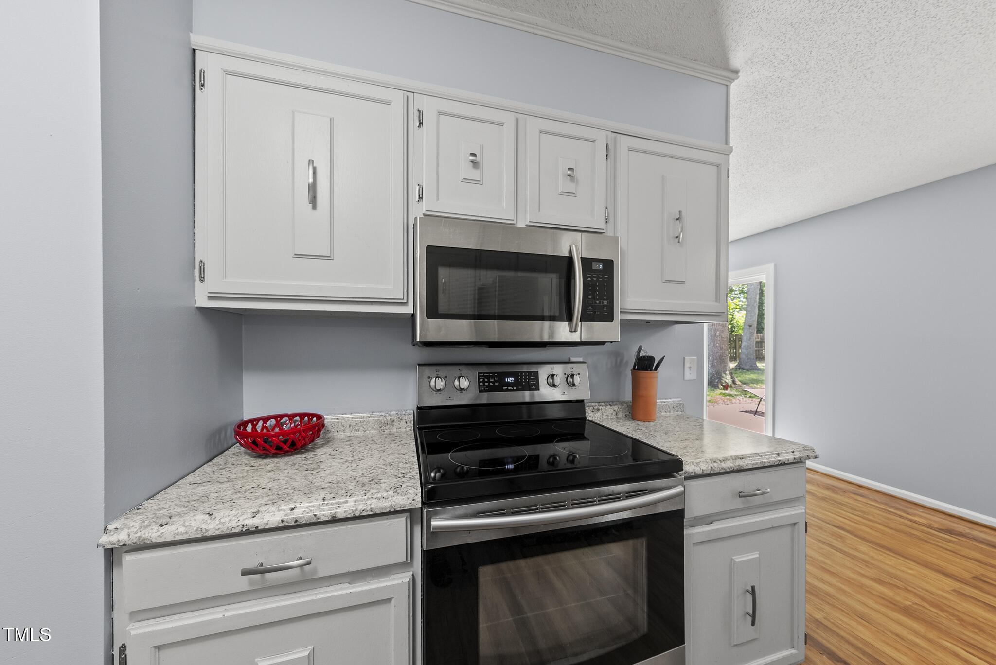 8613 Lobelia Street Raleigh, NC 27603 - Photo 10 of 25 a kitchen with granite countertop white cabinets stainless steel appliances and a sink