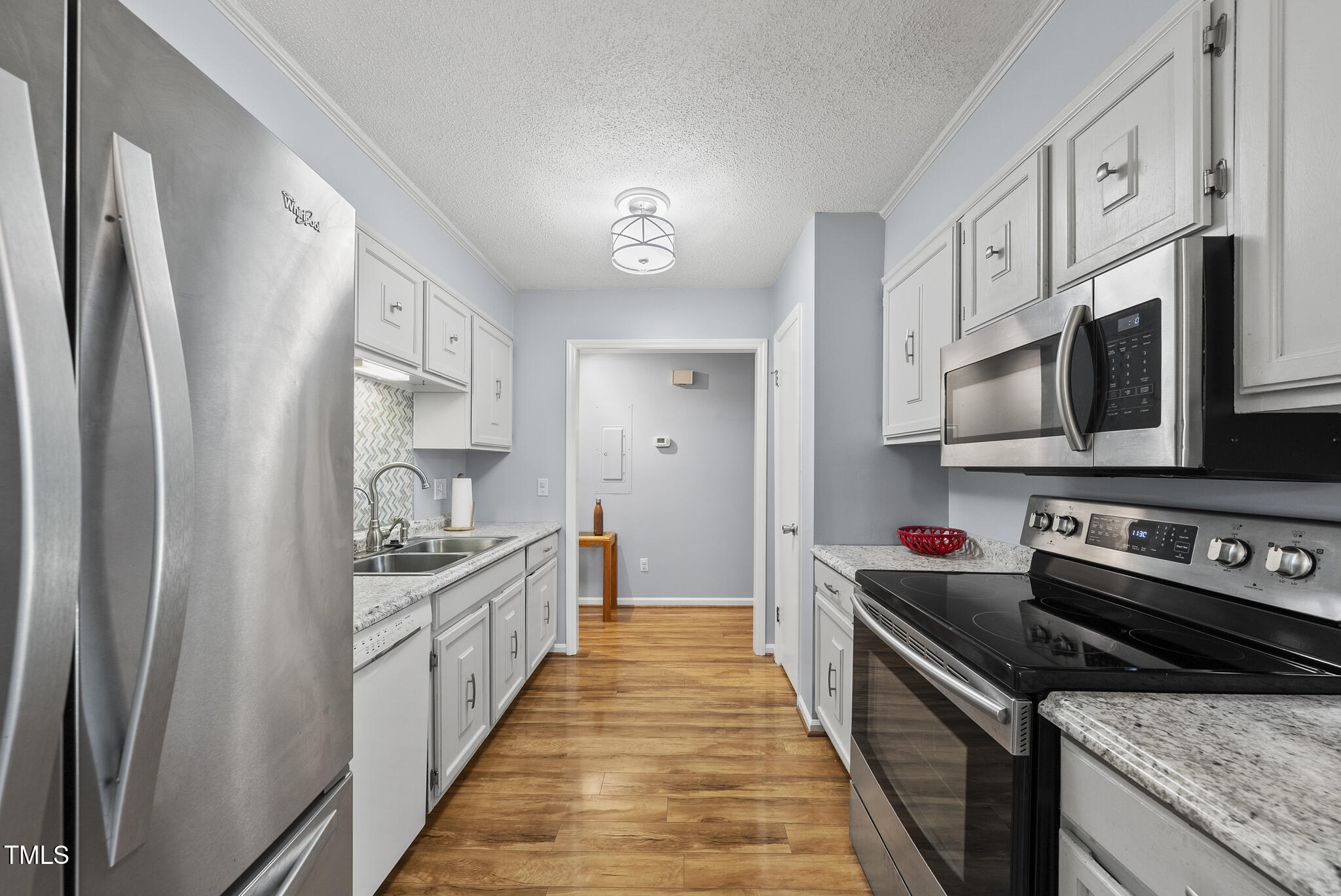 8613 Lobelia Street Raleigh, NC 27603 - Photo 11 of 25 a kitchen with stainless steel appliances a sink stove top oven and cabinets