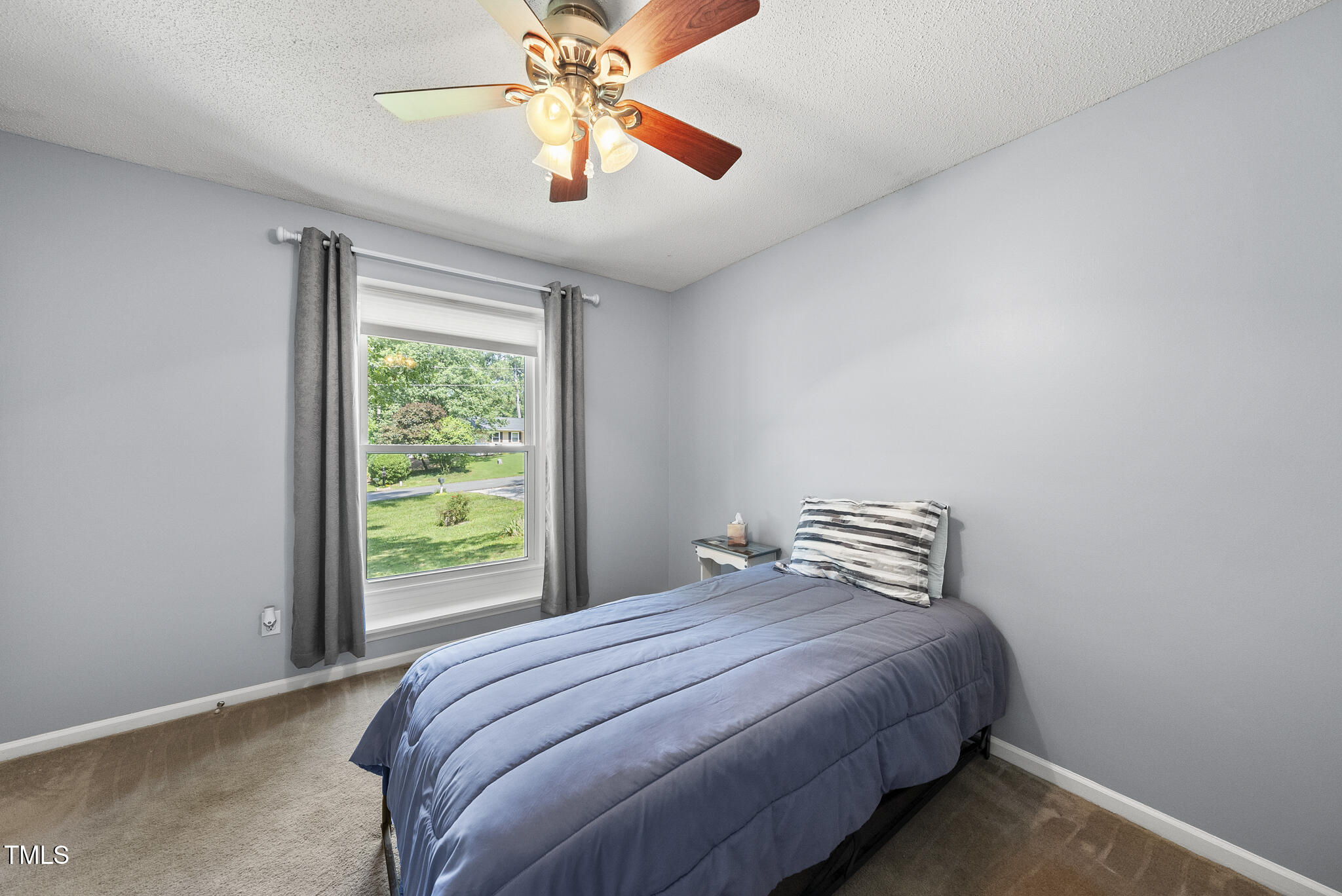 8613 Lobelia Street Raleigh, NC 27603 - Photo 15 of 25 a bedroom with a bed and a chandelier