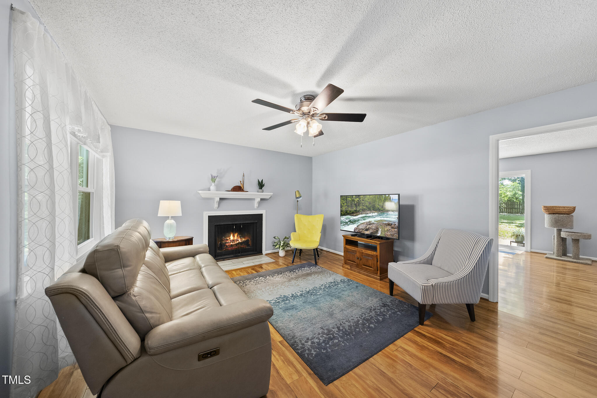 8613 Lobelia Street Raleigh, NC 27603 - Photo 5 of 25 a living room with furniture and a fireplace