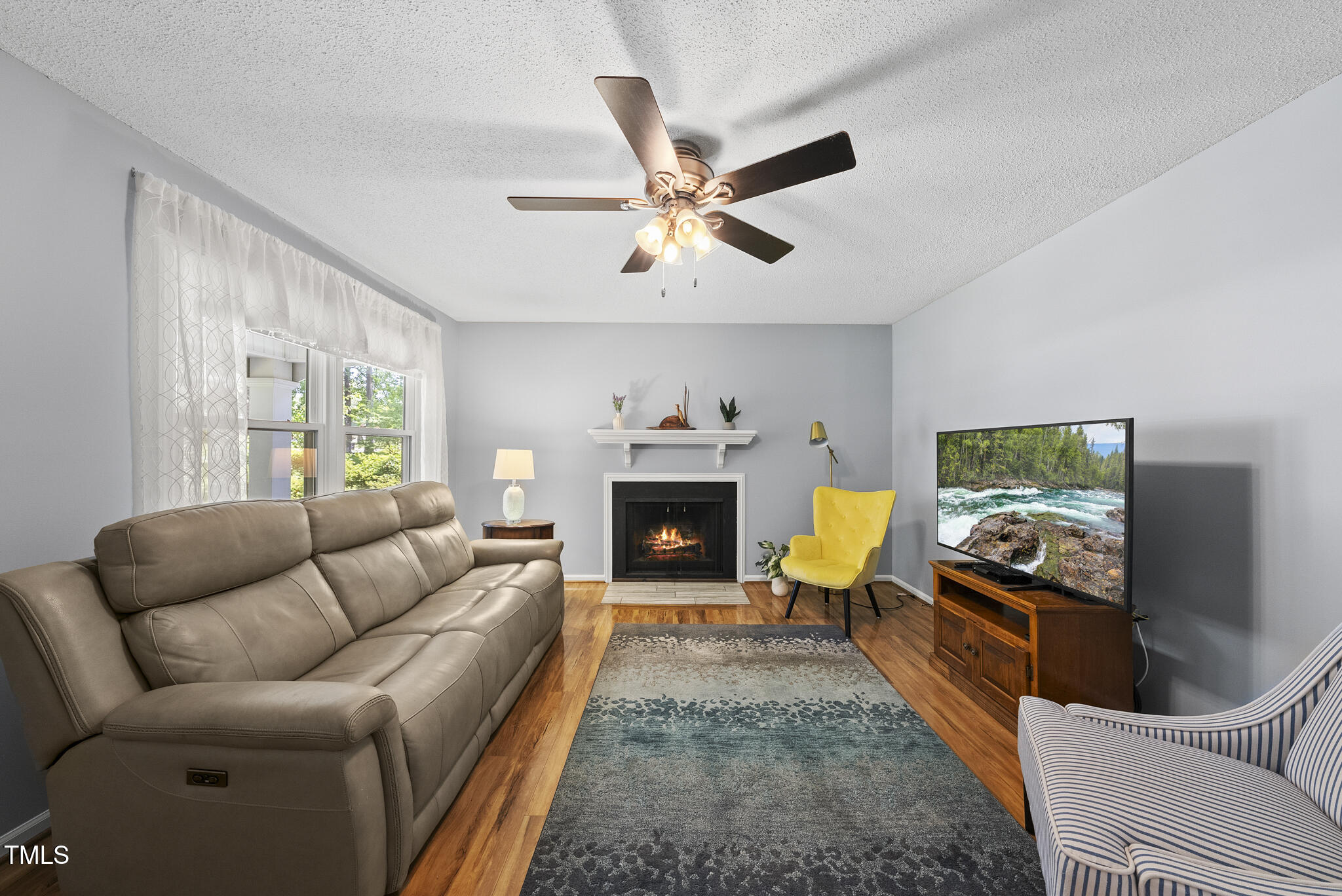 8613 Lobelia Street Raleigh, NC 27603 - Photo 6 of 25 a living room with furniture and a fireplace