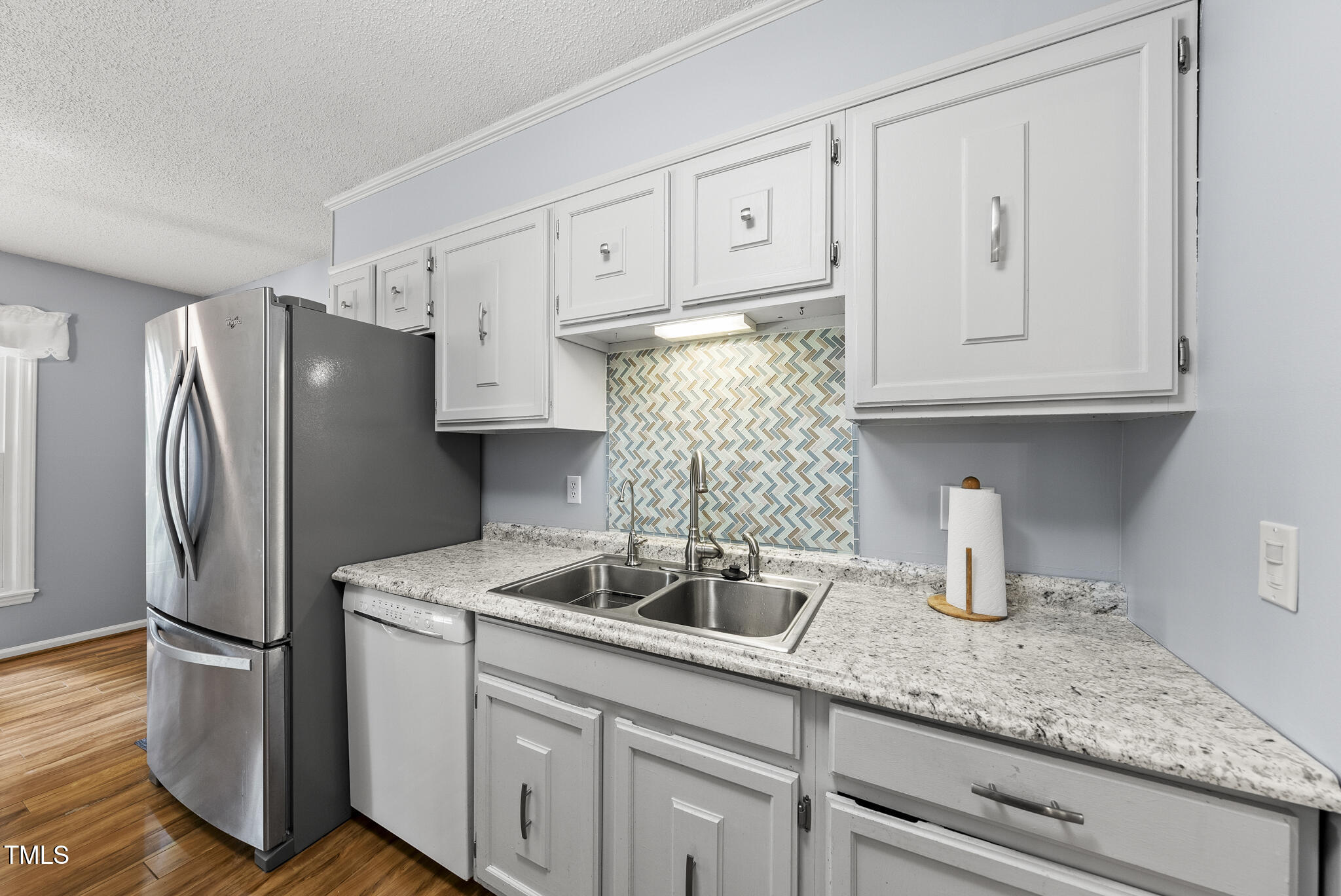 8613 Lobelia Street Raleigh, NC 27603 - Photo 9 of 25 a kitchen with stainless steel appliances granite countertop a refrigerator and a sink