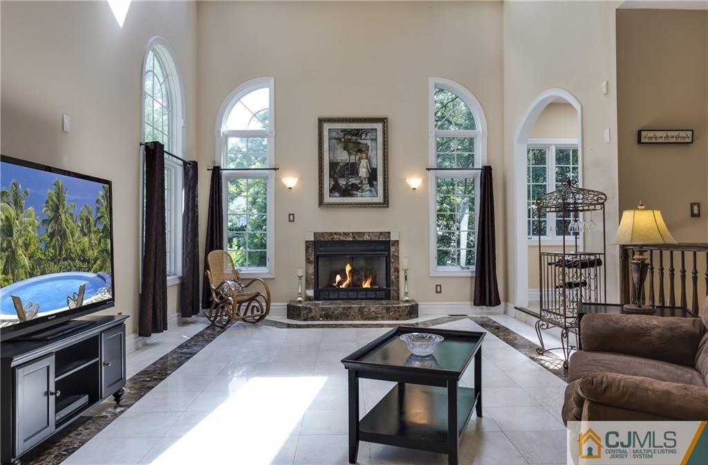 64 Stafford Road Colonia, NJ 07067 - Photo 13 of 25 a living room with furniture a flat screen tv and a fireplace