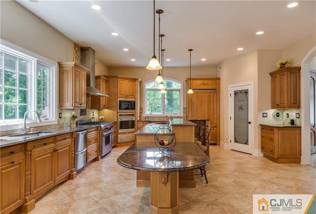 64 Stafford Road Colonia, NJ 07067 - Photo 7 of 25 a kitchen with stainless steel appliances granite countertop a sink a stove a refrigerator cabinets and chairs