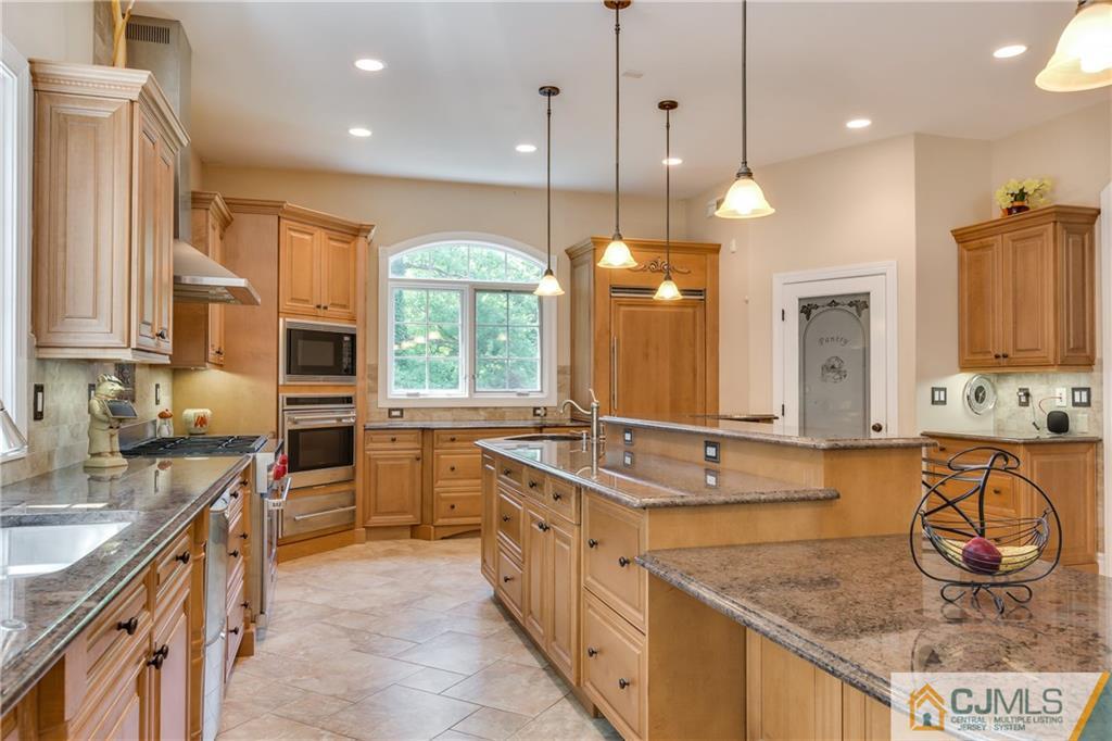 64 Stafford Road Colonia, NJ 07067 - Photo 9 of 25 a large kitchen with kitchen island a large counter space a sink stainless steel appliances and cabinets