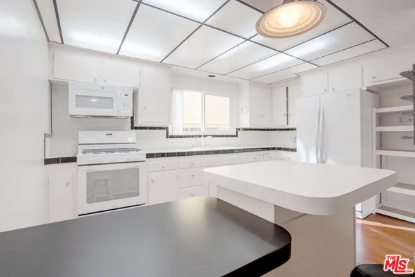 a kitchen with a sink a stove and cabinets
