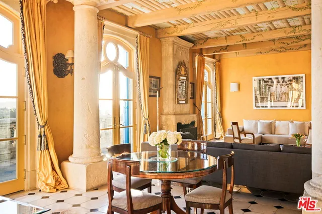 a bedroom with a bed wooden floor and a large window