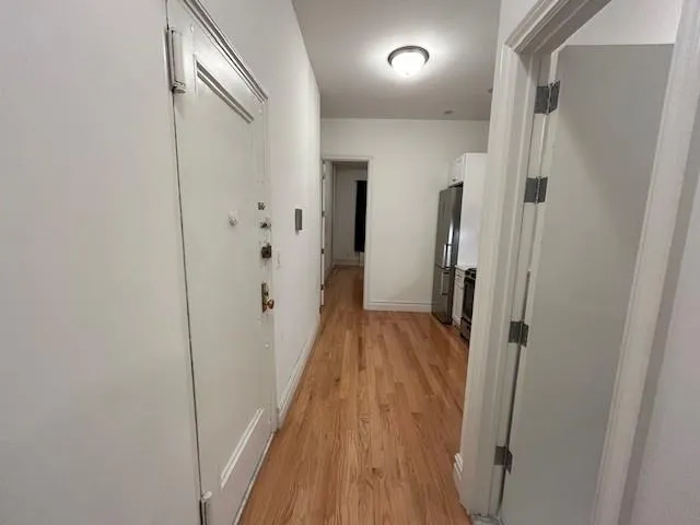 a view of a hallway with wooden floor and staircase