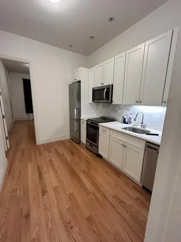 a kitchen with a sink window and cabinets