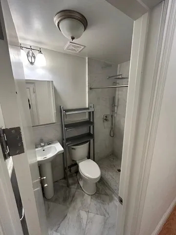a bathroom with a toilet sink and mirror