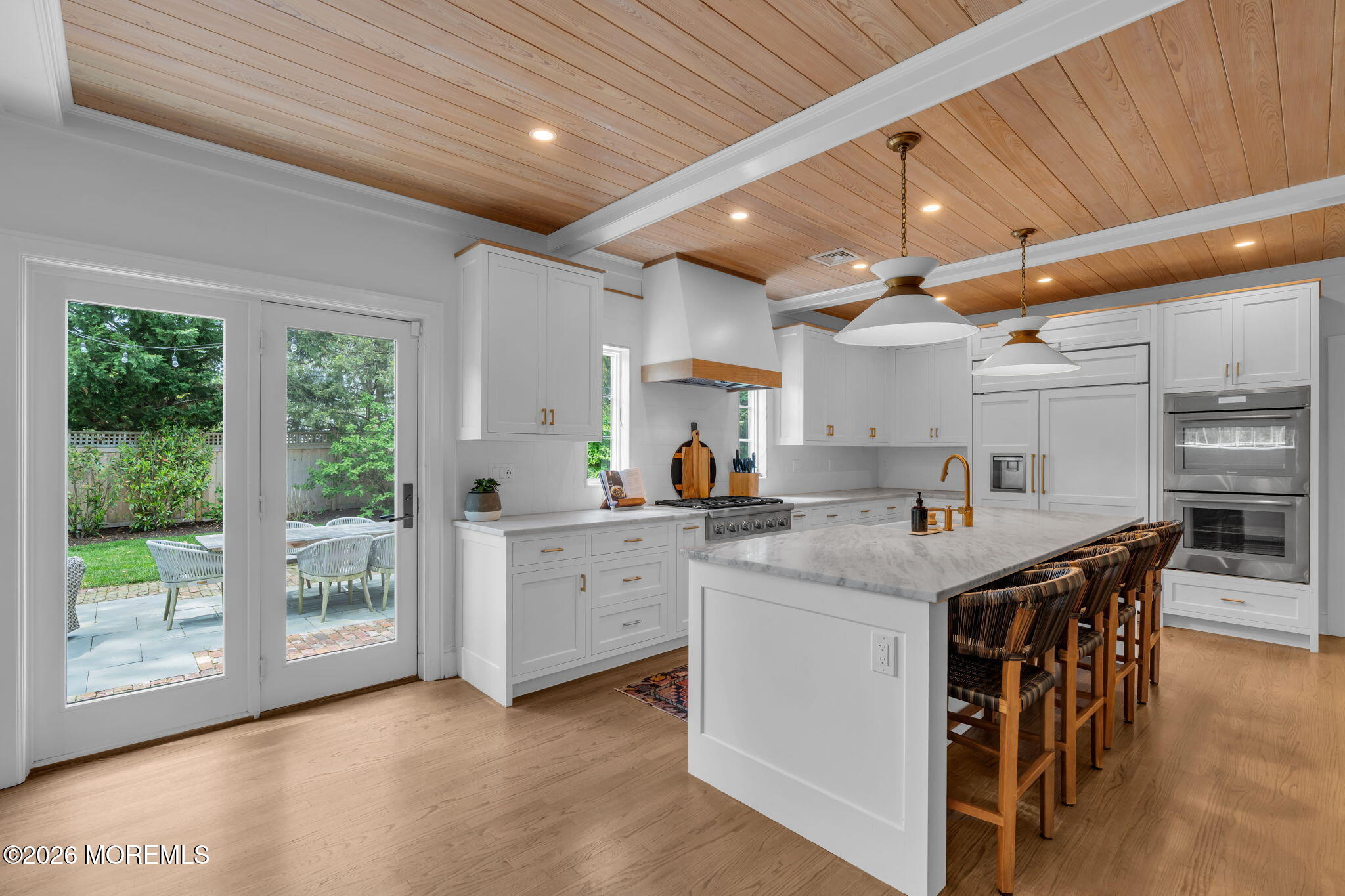22 1st Street Rumson, NJ 07760 - Photo 10 of 44 a kitchen with stainless steel appliances granite countertop a stove a refrigerator a sink dishwasher with a dining table and chairs with wooden floor